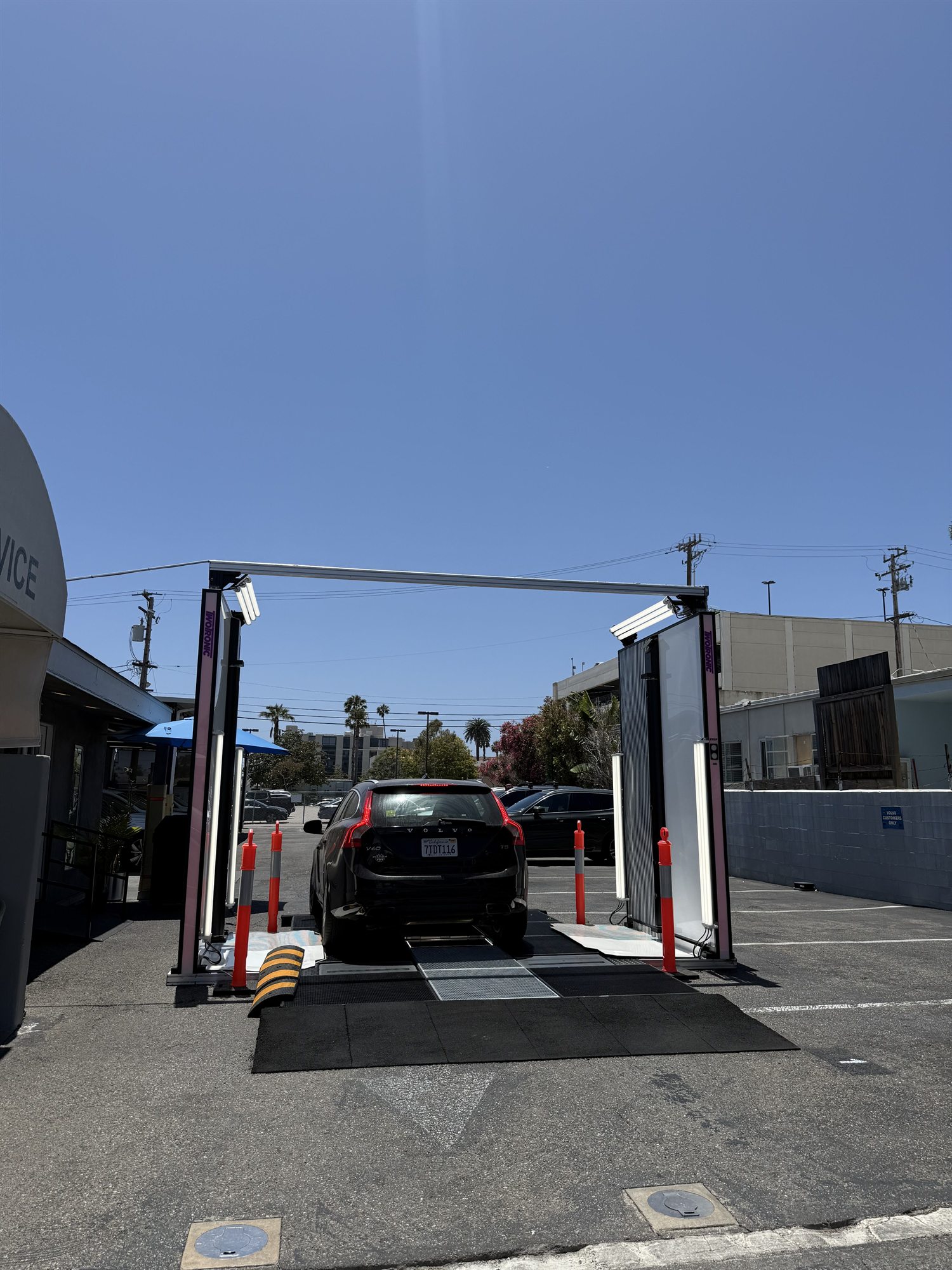 A compact SUV positioned in the outdoor scanning gate on the dealership service drive