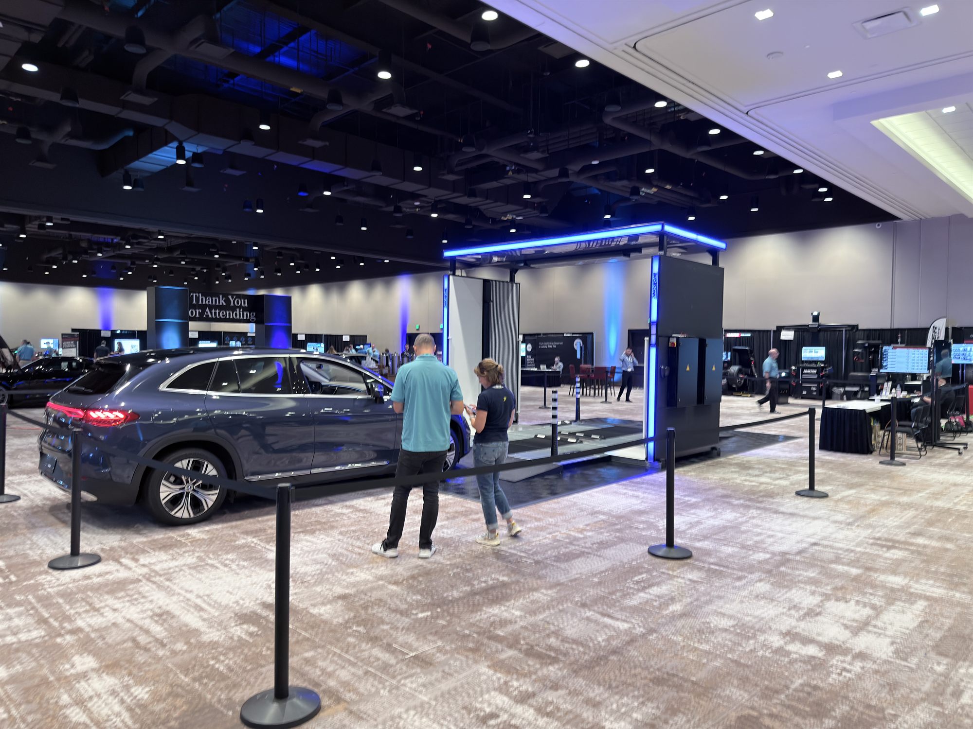 The latest-generation TwoTronic scanning gate with an electric SUV in the lane and visitors alongside