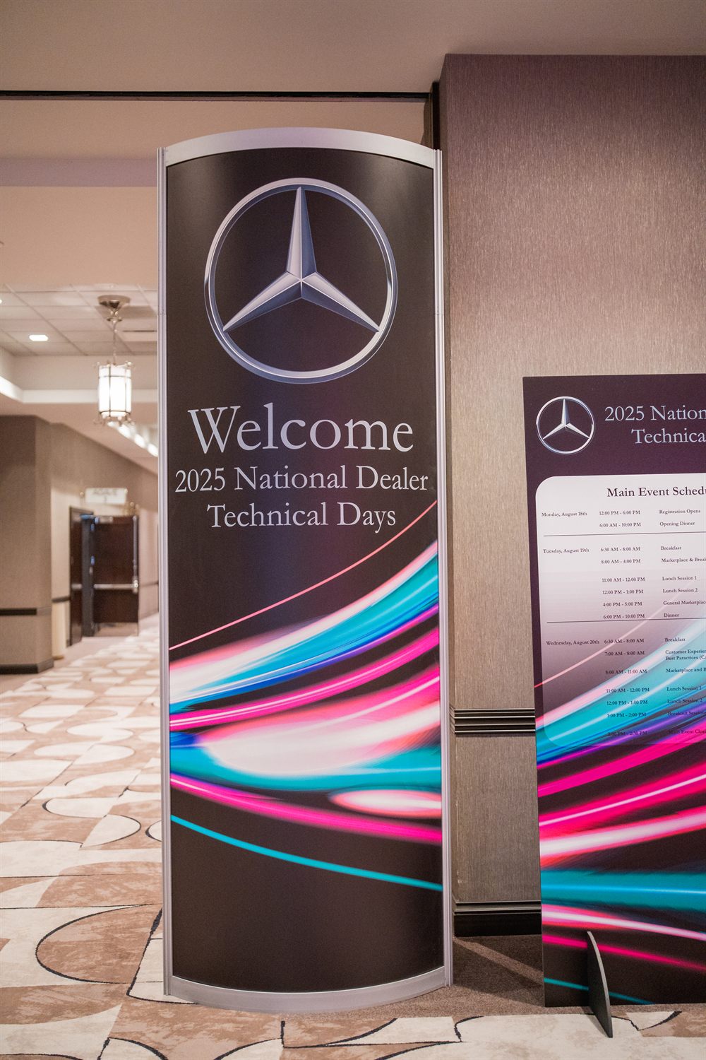Welcome banner for the 2025 National Dealer Technical Days beside the event schedule