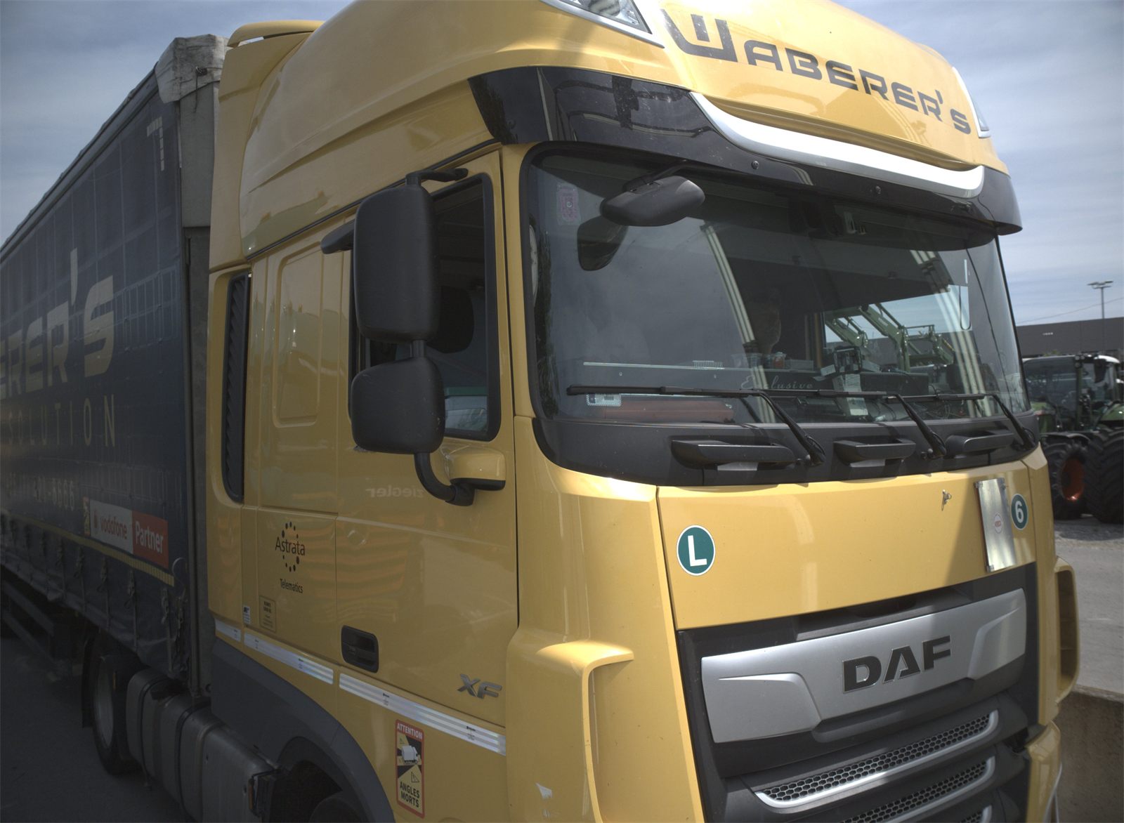 A commercial truck at a scanning site with agricultural machines lined up behind it