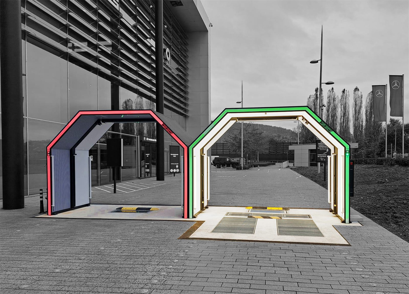 Two scanner gates side by side at a large dealership, one showing a red stop signal and one a green go signal
