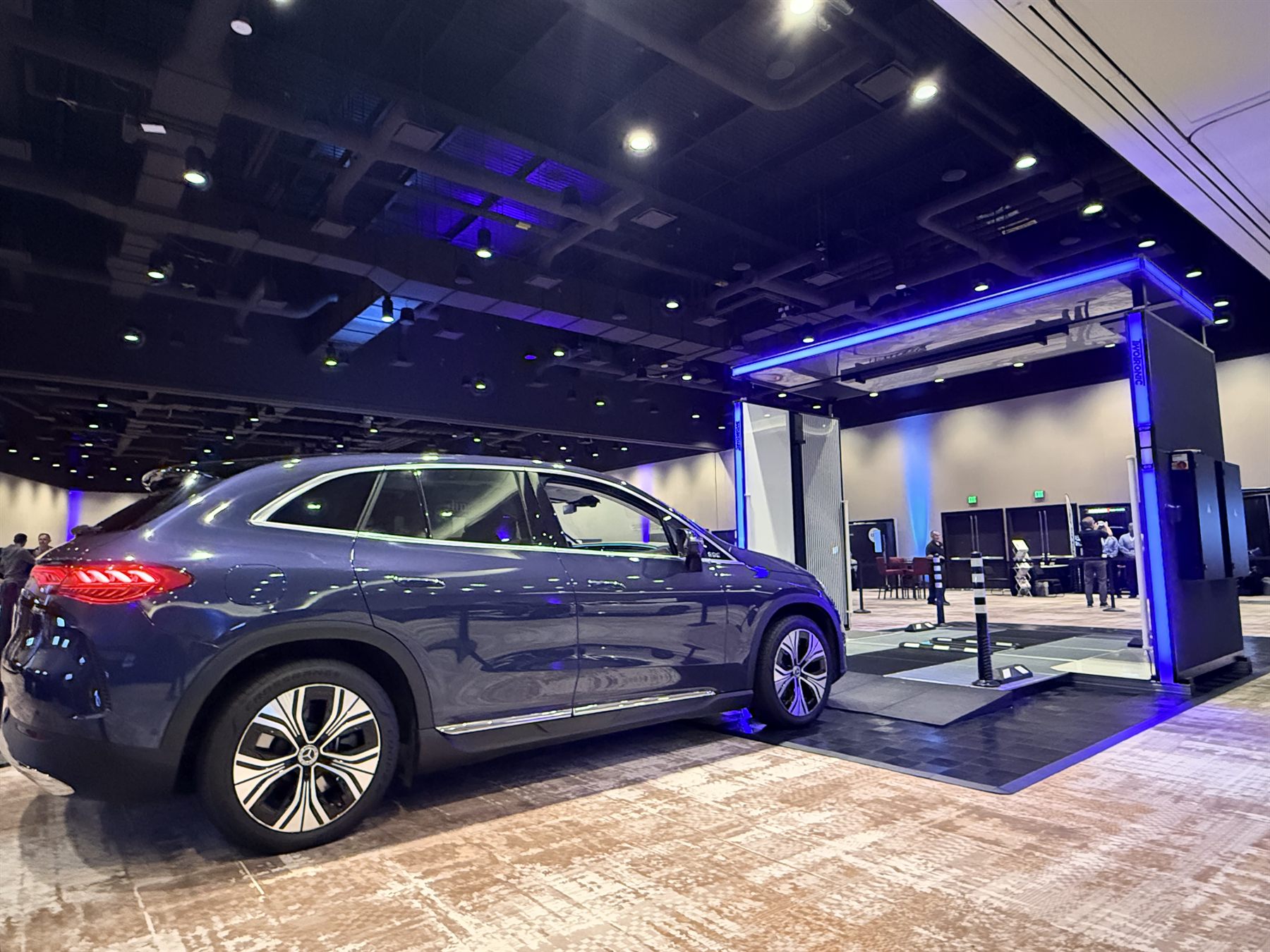 The latest TwoTronic scanner with its illuminated blue gate and an electric SUV at a national dealer event